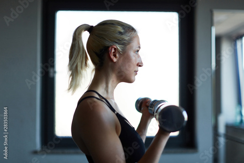 Frau im Fitnesscenter trainiert mit Kurzhanteln © Robert Kneschke