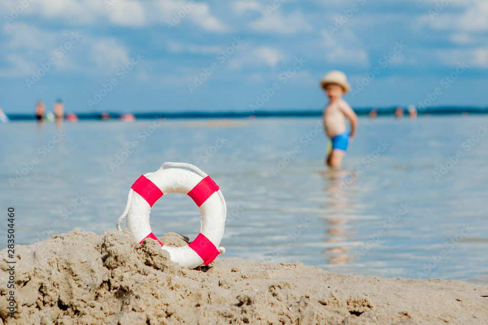 Close-up Of Lifebuoy on the beach on baby background. Safety on the water.