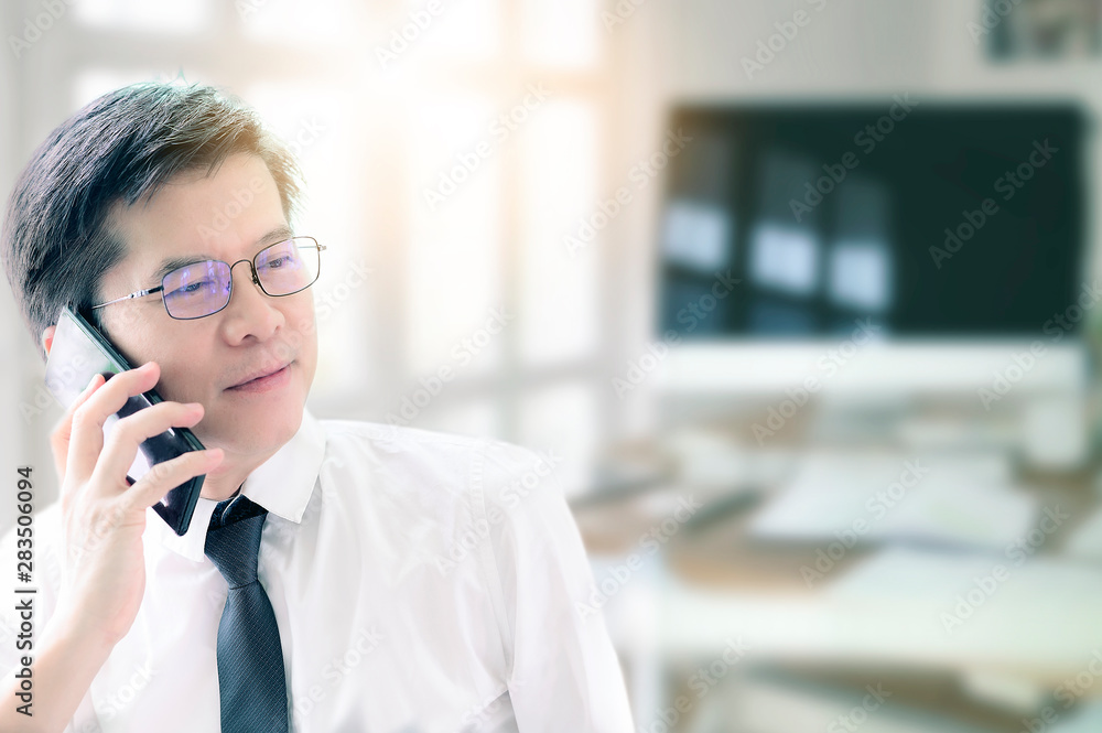 Asian Businessman in white shirt with glasses Using Mobile Phone In Office. Asian Businessman in white shirt with glasses Using Mobile Phone In Office.