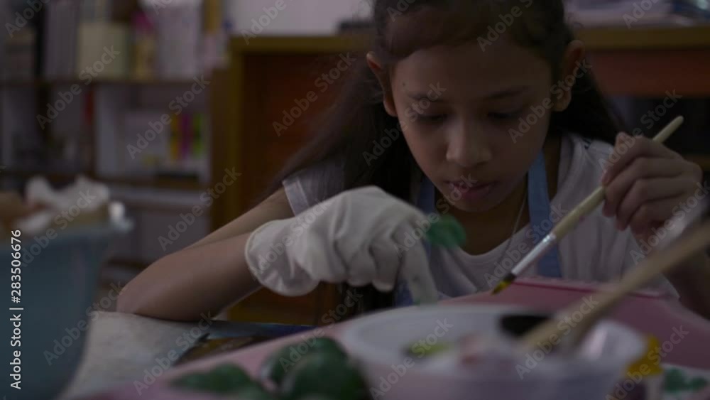 Asian cute girl is making crafts from egg shells on the desk, Young girl is coloring egg shells at home for her homework, Education concept. Asian cute girl is making crafts from egg shells on the desk, Young girl is coloring egg shells at home for her homework, Education concept.