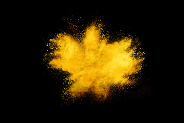 Yellow powder explosion on black background.