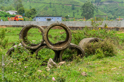 Concrete pipe in a green field