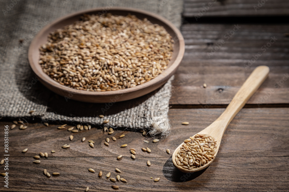 Flax seeds on wooden plate and wooden spoon, on wooden base. Flax seeds on wooden plate and wooden spoon, on wooden base.