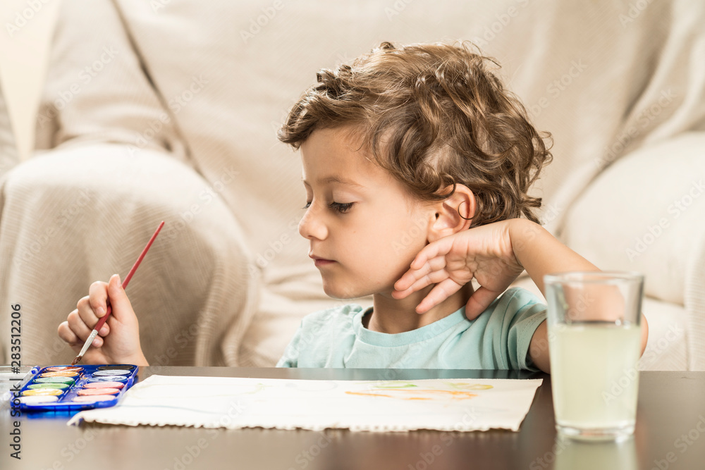 Child painting with watercolors on paper. Child painting with watercolors on paper.