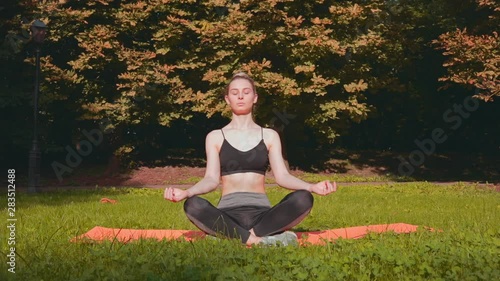 Wallpaper Mural Beautiful girl meditation in morning sunny park. Woman doing yoga in the park. Healthy sports lifestyle. Torontodigital.ca