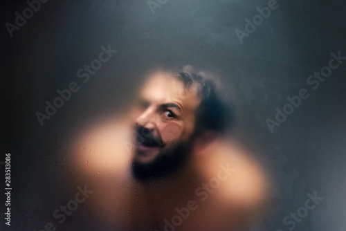 Fotografi Creepy looking man with one eye behind a frosted glass.