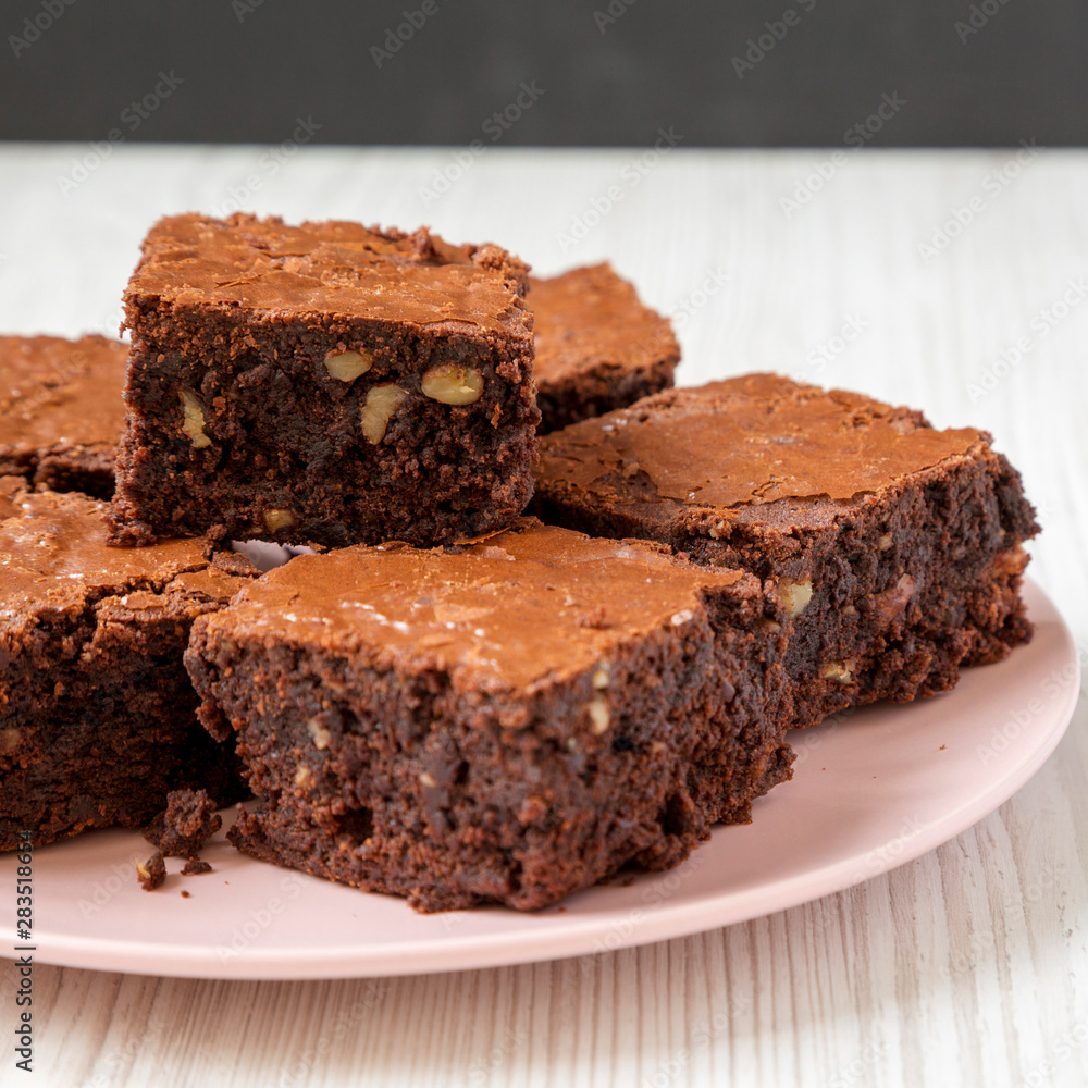 Homemade chocolate brownies on a pink plate, side view. Close-up. Homemade chocolate brownies on a pink plate, side view. Close-up.