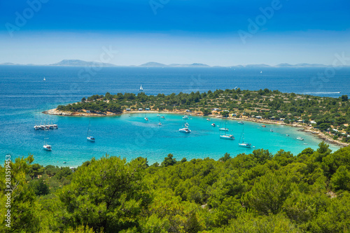 Panoramic view on Kosirina beach lagoon on Murter island in Croatia, anchored sailing boats and yachts on blue sea