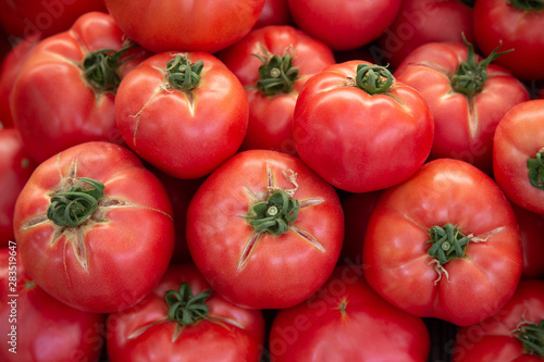 Market fresh organic ripe tomato stacked together for maximum sale attraction. Background food.