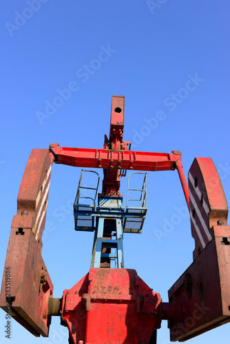 The beam pumping unit is working against the blue sky