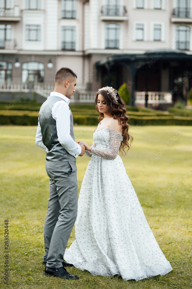 Young loving couple hugging and dancing on the green grass. Beautiful and happy woman and man gently touch each other. Beautiful couple in love. girl in the dress and the guy in the shirt. Young loving couple hugging and dancing on the green grass. Beautiful and happy woman and man gently touch each other. Beautiful couple in love. girl in the dress and the guy in the shirt.