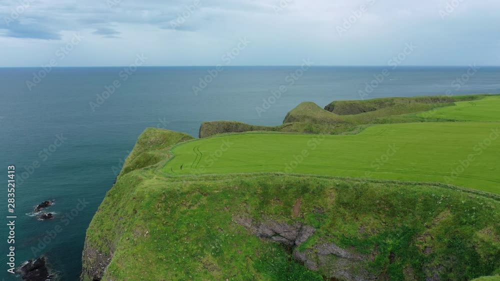 Aerial view of picturesque lush green cliffs around Dunnottar Castle, northeastern coast of Scotland, North Sea - landscape panorama of Aberdeenshire from above, United Kingdom, Great Britain, Europe Aerial view of picturesque lush green cliffs around Dunnottar Castle, northeastern coast of Scotland, North Sea - landscape panorama of Aberdeenshire from above, United Kingdom, Great Britain, Europe