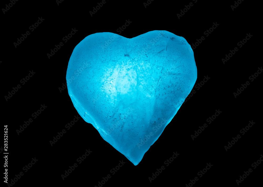 Close-up blue ice frozen heart symbol isolated on a black background. Texture of ice. Close-up blue ice frozen heart symbol isolated on a black background. Texture of ice.