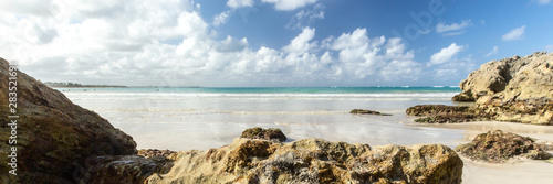 Panorama of a wild beach in the sandy bay of the blue tropical sea