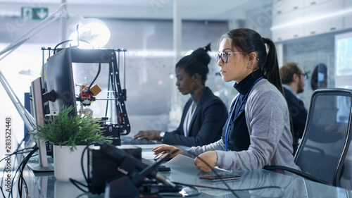 White Female Working on a Computer with Her Colleagus in a Modern High-Tech Laboratory. photo