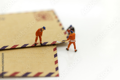 Miniature people : Postman sorting the mail For sending to the destination recipient. Image use for business transportation concept.