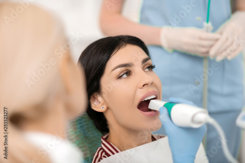 Woman opening her mouth for X-ray of her tooth.