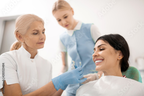 Dentist trying teeth whitening samples for her patient.