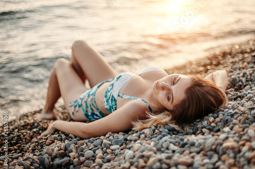 Beautiful girl in swimsuit sunning on sea