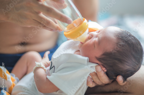 Newborn infant baby boy eat milk feed by father