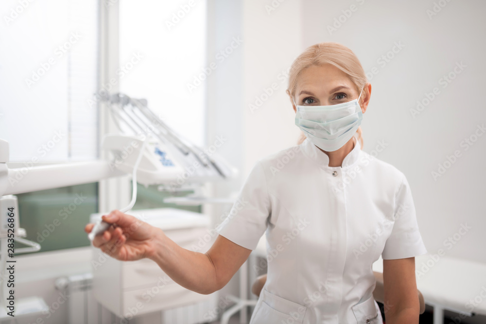 Dentist before drilling a tooth of her patient. Dentist before drilling a tooth of her patient.