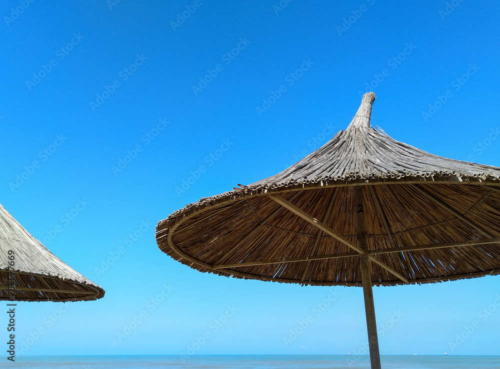 Straw umbrellas against a blue sky. Parasols. Straw umbrellas against a blue sky. Parasols.