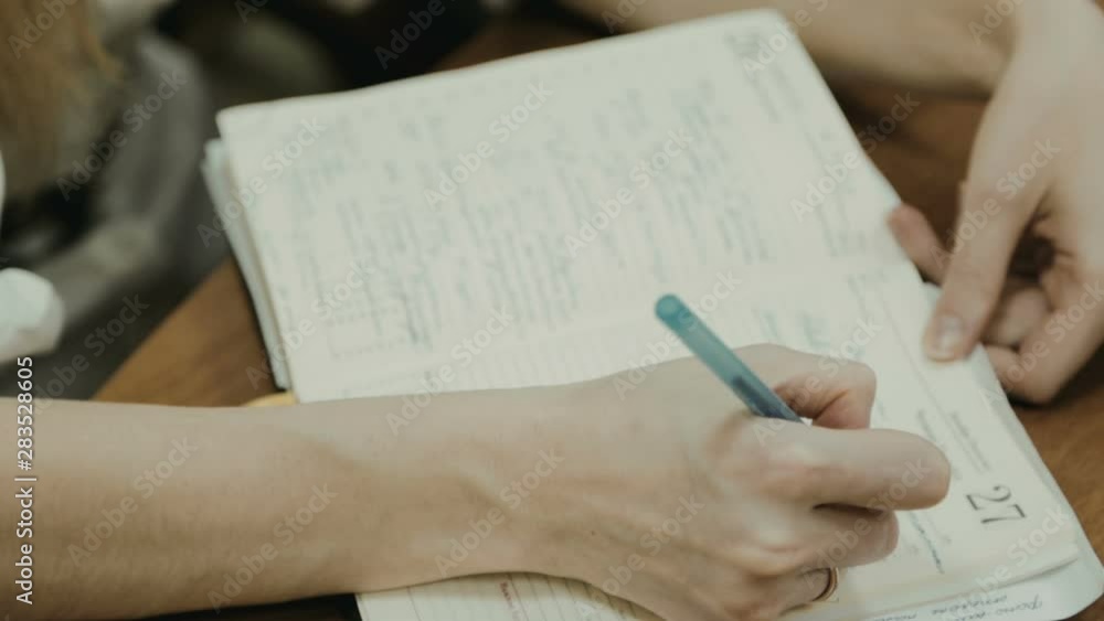 Businesswoman writes a handle in the diary Businesswoman writes a handle in the diary