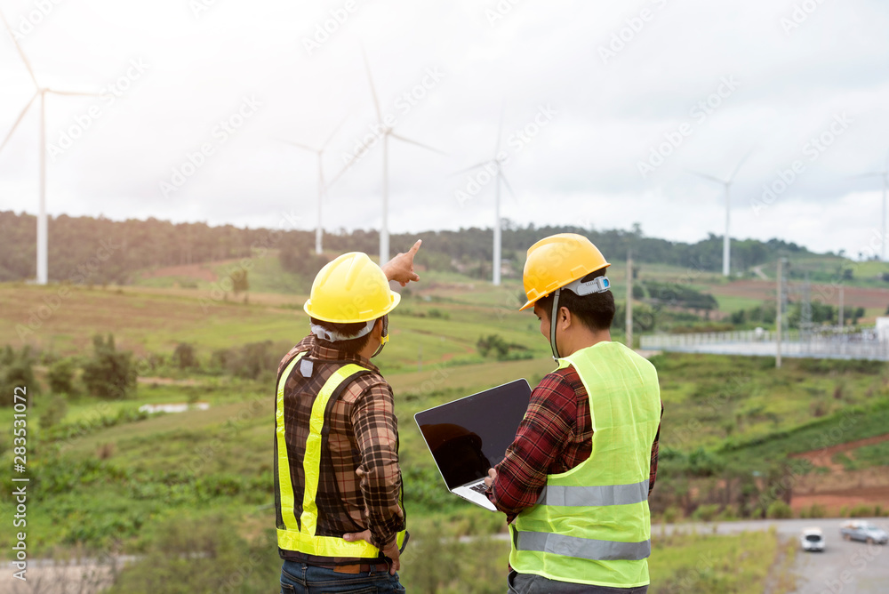 Engineers and supervisors in the wind turbine power industry check the operation system.