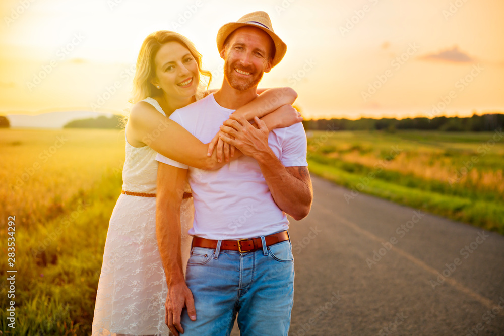 happy couple at sunset. Man and woman having fun playing in nature