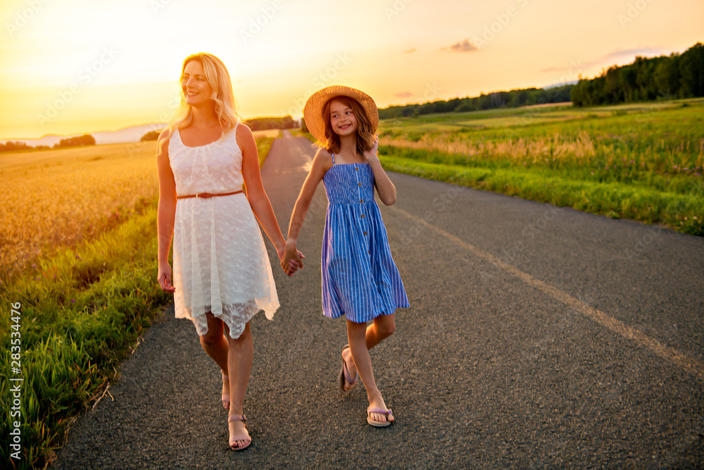 happy family at sunset. Mother and daughter having fun and playing in nature happy family at sunset. Mother and daughter having fun and playing in nature