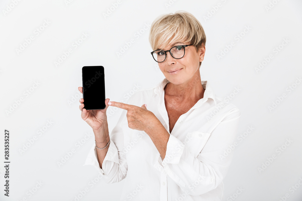 Portrait of smiling adult woman with short blond hair holding cellphone and showing black screen