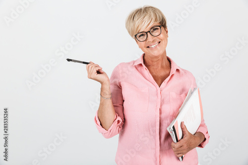 Portrait of blond adult woman wearing eyeglasses holding studying books and pen
