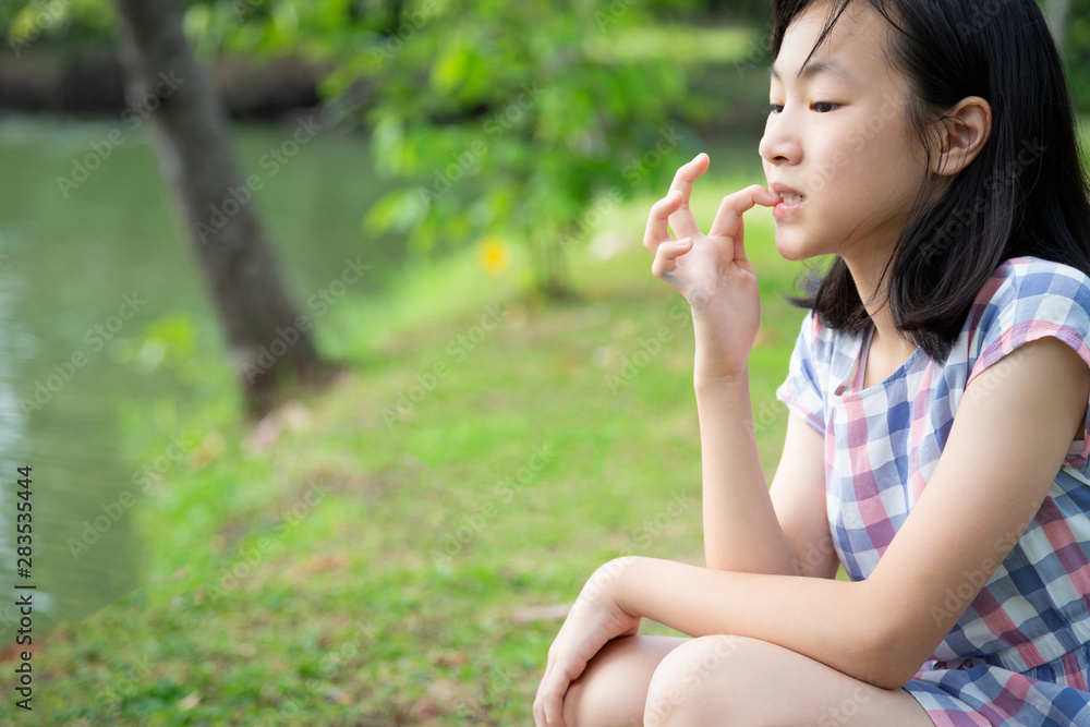 Asian little child girl feeling stressed,female worried bites finger nails in park,girl patient with nervous expression,nail biting,anxious with hand on mouth biting her nails,anxiety problem, Asian little child girl feeling stressed,female worried bites finger nails in park,girl patient with nervous expression,nail biting,anxious with hand on mouth biting her nails,anxiety problem,