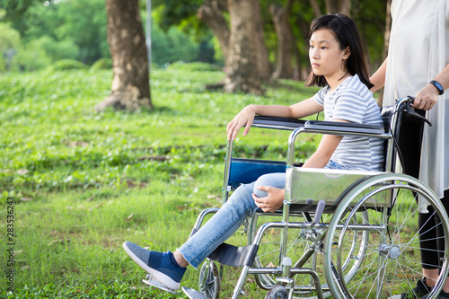 Foto Disabled daughter in wheelchair feeling sad,asian little child girl with depress