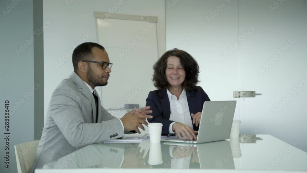 Cheerful business consultant talking with client in office. Two employees talking during meeting in office. Business meeting concept Cheerful business consultant talking with client in office. Two employees talking during meeting in office. Business meeting concept