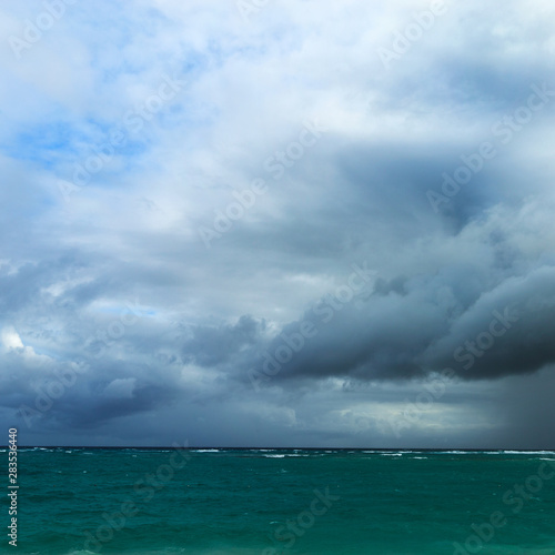The beginning of a storm on a wild ocean beach in a sandy bay of a blue tropical sea © zoommachine