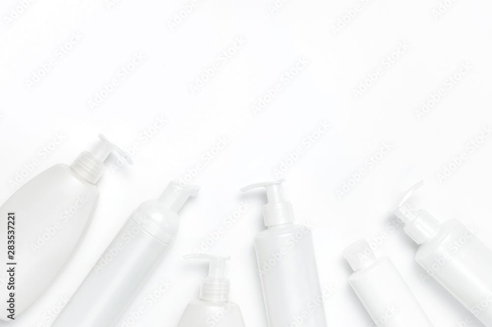 White cosmetic bottle containers on white background top view flat lay with space for text. Cosmetics SPA branding mock-up, Natural organic beauty product concept, Minimalism cosmetics style White cosmetic bottle containers on white background top view flat lay with space for text. Cosmetics SPA branding mock-up, Natural organic beauty product concept, Minimalism cosmetics style