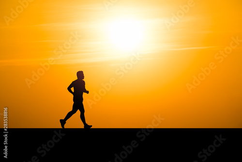 Silhouette man running on sunset background