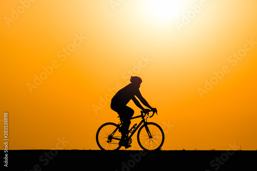 Fototapeta Naklejka Na Ścianę i Meble -  Silhouette man cycling on sunset background
