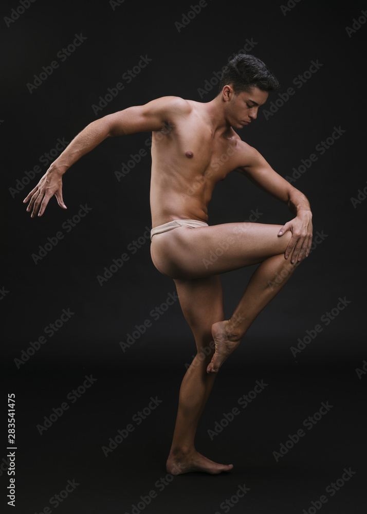 Muscular dancer stretching leg
