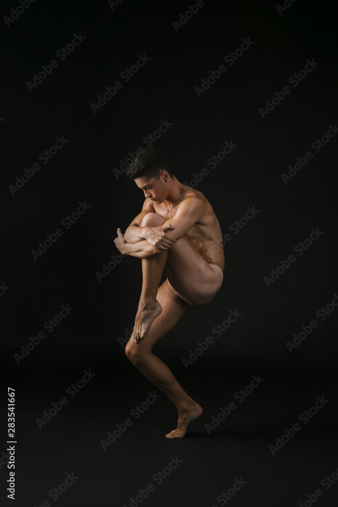 Nude dancer hugging knee