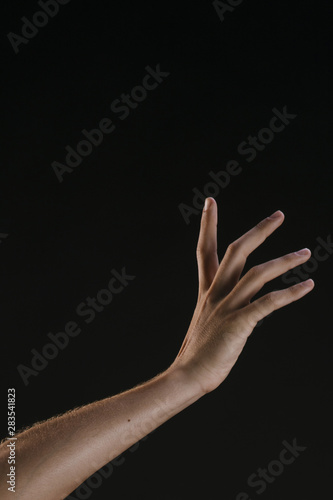 Beautiful hand with fingers spread on black background