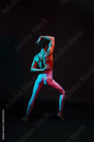Unrecognizable dancer in leotard performing with arms bent behind back © Freepik