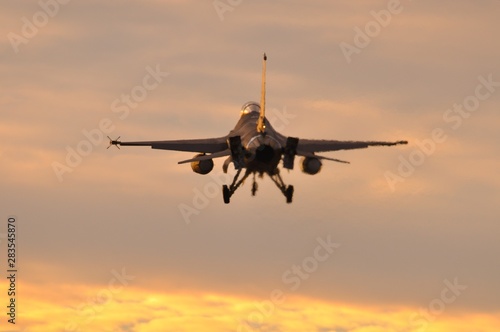 Reactor de combate F-16 aterrizando al anochecer