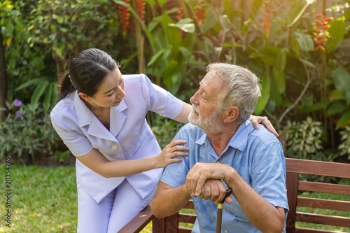 Nurse take care and comfort depressed elderly man in garden at nursing home © wirojsid