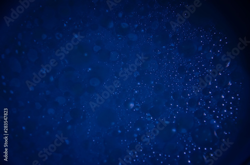 Abstract bubbles dark blue bokeh background