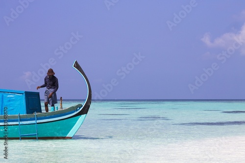 Ari Atoll, Maldives - 25 December 2018: A maldivian sailor is fishing on his boat