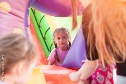 A cheerful child plays in an inflatable castle