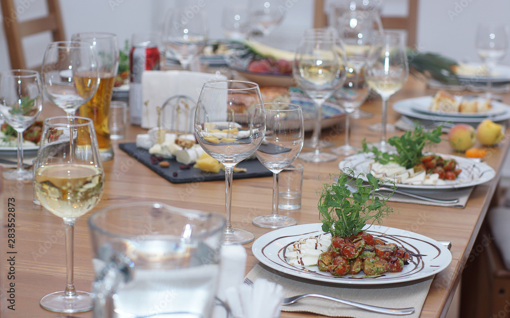 On a served table is a freshly prepared caprese salad with pesto and cherry tomatoes for several people