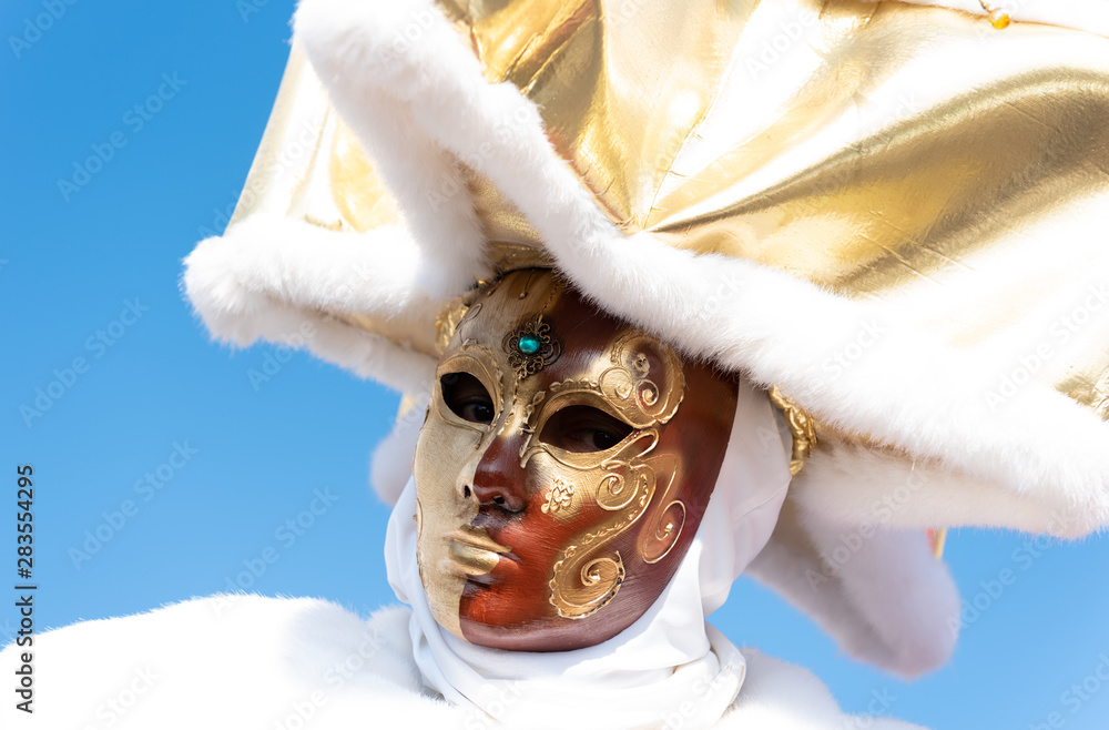Mysterious mask with white dress, hand's painted mask adorned with gem and  white and gold hat, during the traditional carnival in Venice, with a blu  sky on background. Stock Photo | Adobe